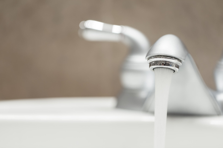 Bathroom faucet with running waterの写真素材