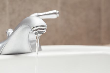 Bathroom faucet with running waterの写真素材