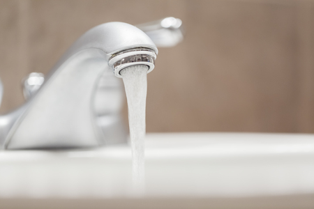 Bathroom faucet with running waterの写真素材