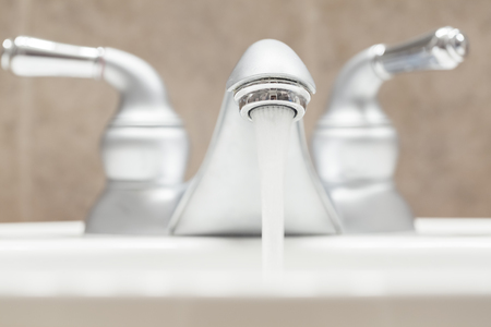 Bathroom faucet with running waterの写真素材