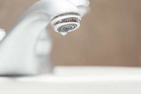Bathroom faucet with dripping water close-upの写真素材