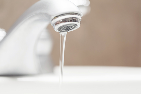 Bathroom faucet with running waterの写真素材