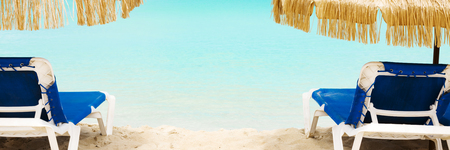 Two beach chairs over turquoise waters of caribbean beachの写真素材