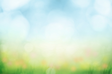 Abstract background with green grass and flowers over sunny blue skyの写真素材