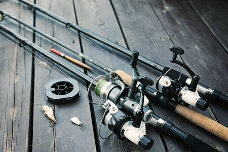 Fishing rods and accessories on wooden  with text spaceの写真素材