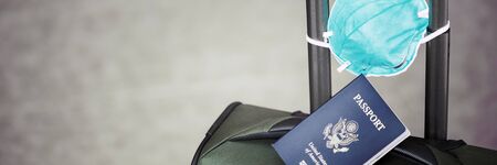 personal luggage with passport and flu virus mask to protect against coronavirus, global epidemic...