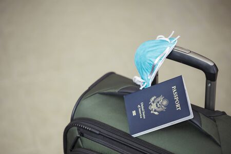 personal luggage with passport and flu virus mask to protect against coronavirus, global epidemic conceptの写真素材
