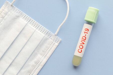 test tube with sample of coronavirus covid-19 and medical mask, deadly global pandemic conceptの写真素材