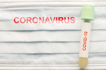 test tube with sample of coronavirus covid-19 and medical mask, deadly global pandemic conceptの写真素材