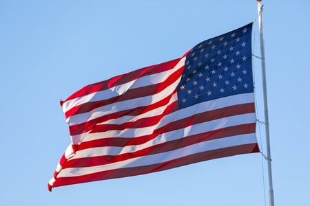 American flag waving in the wind on blue skyの写真素材