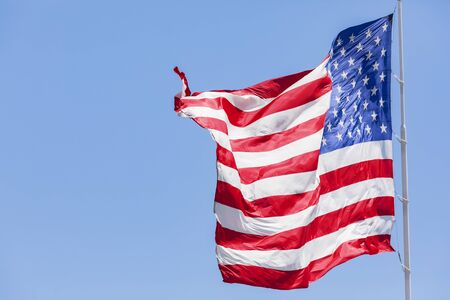 American flag waving in the wind on blue skyの写真素材