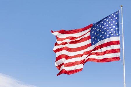 American flag waving in the wind, US flag motion on blue sky, United States of America national flag. USA stars and stripesの写真素材