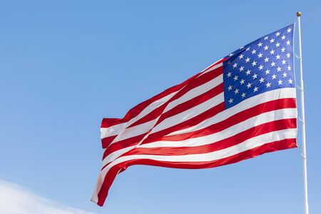 American flag waving in the wind, US flag motion on blue sky, United States of America national flag. USA stars and stripesの写真素材
