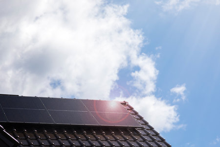 Solar panels on the house roof in sunny day. Renewable clean green energy generation.