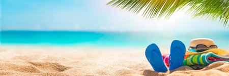 Beach background with flip flops, sunglasses and hat on the sandの写真素材