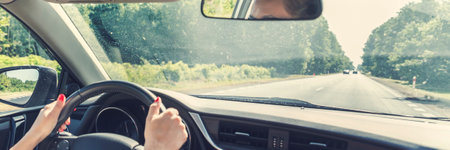 woman driving a car on the road. panoramic view.の写真素材