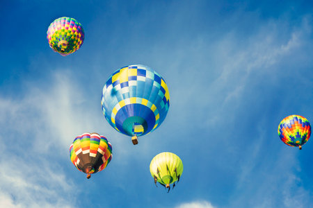 Hot air balloons fly in the blue sky at the annual International Balloon Fiesta in Albuquerque, New Mexico.の写真素材