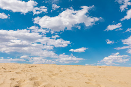 Sand dunes and blue sky with white clouds, natural background.の写真素材