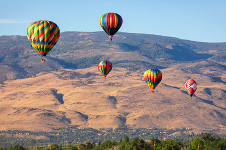 Colorful hot air balloons flying over the mountainsの写真素材