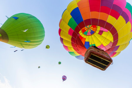 Colorful hot air balloons flying in the blue sky at the festivalの写真素材