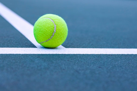 Tennis ball on the tennis court with white line, soft focusの写真素材