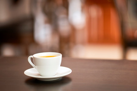 Coffee cup on wooden table in coffee shop blur background with bokeh image.の写真素材