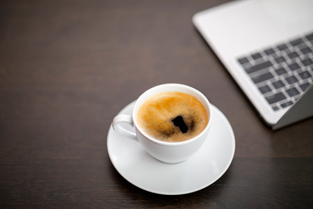 Coffee cup with laptop computer on wooden table, stock photoの写真素材