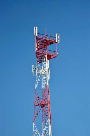 Mobile phone cellular telecommunication radio antenna tower. Cell phone tower against blue skyの写真素材