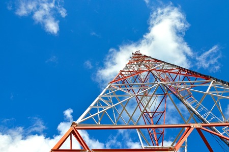 Mobile phone cellular telecommunication radio tv antenna tower against blue sky