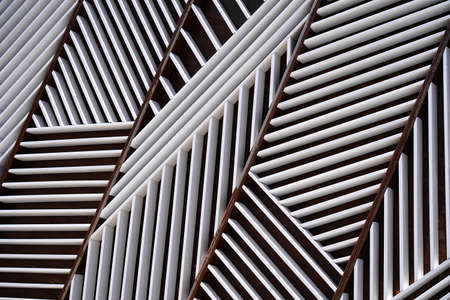 The wall is made of white and brown wooden boards, parallel inclined boards of white color,...