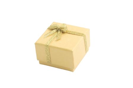 Yellow gift box with gold ribbon isolated on whiteの写真素材