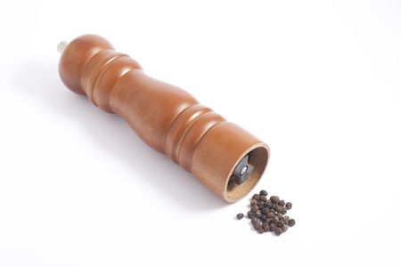 Wooden pepper grinder and pepper grains on white backgroundの写真素材