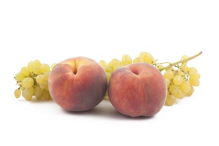 Two peaches and grapes branch on white backgroundの写真素材