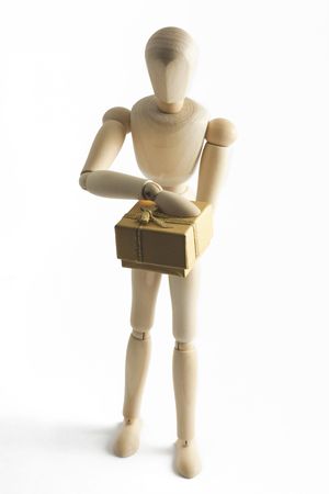 Wooden mannequin with a yellow gift box with golden ribbonの写真素材