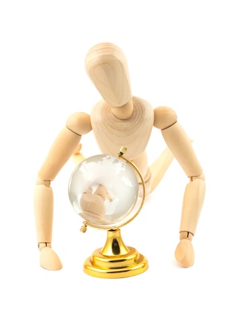 Wooden dummy and glass earth globe on white backgroundの写真素材
