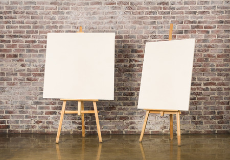 Pair of Easel with blank canvas on a brick wall backgroundの写真素材