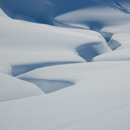 White snow with highlights and shadows only. Natrual shapes in deep snow created by an underlaying flood of water.の写真素材