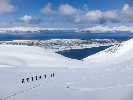 A group of people randonee ski walking high above the fjords. Lyngen Alps, Norwayの写真素材