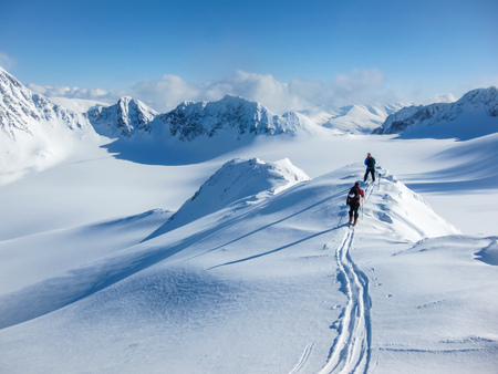 High alltitude view of two skiiers walking on a mountain ridge in the Lyngen Alps, Norwayの写真素材