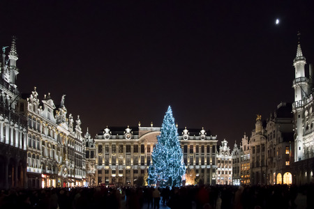 Night view of the crowded christmas market at Grand Place in Brussels, Belgium. Illuminated gothic buildings and christmas tree.のeditorial素材