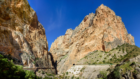 Caminito del Ray walking trail and via ferrata through the canyon. Panorama view with the train track and tunnel on opposite side. Spain.の写真素材