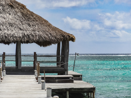 Looking down a long dock on the beach in san pedro belize central americaの写真素材