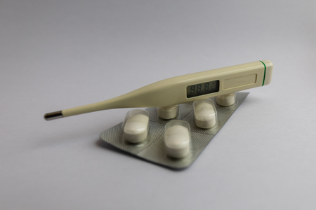 white pills in blister pack with thermometer on white background, medicineの写真素材