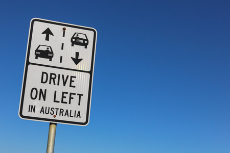 Drive on left in Australia sign against a clear blue skyの写真素材