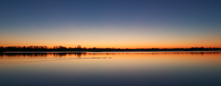 Cold winter sunset at Reeuwijk lake district under a blue and orange sky, panorama