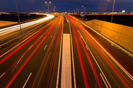 Busy rush hour traffic leaves light trails on the A9 highway near Amsterdam, Schiphol to Haarlem.の写真素材