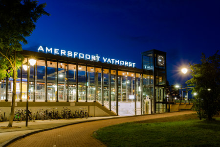 Amersfoort, The Netherlands - September 08, 2019: Illuminated train station Amersfoort Vathorst during blue hour with empty platform and parked bikes with no passengers.のeditorial素材