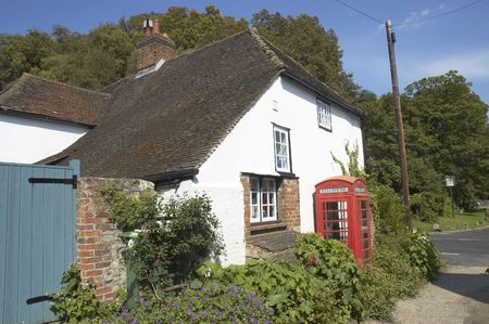 A village phonebox by a white cottageの写真素材
