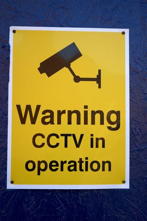 A cctv warning sign on a blue wallの写真素材