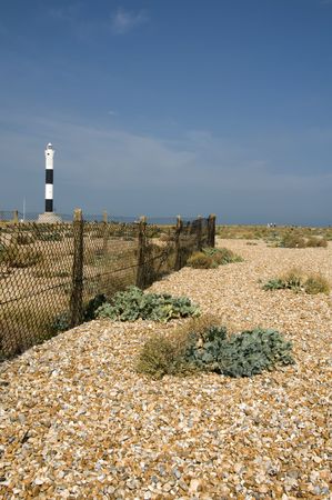 The pebble  at Dungeness with the new lighthouse in the distanceの写真素材